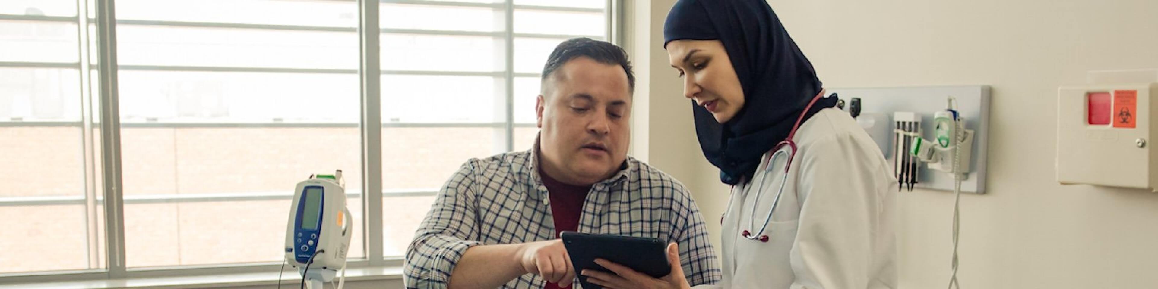 Female doctor sharing data with patient using tablet