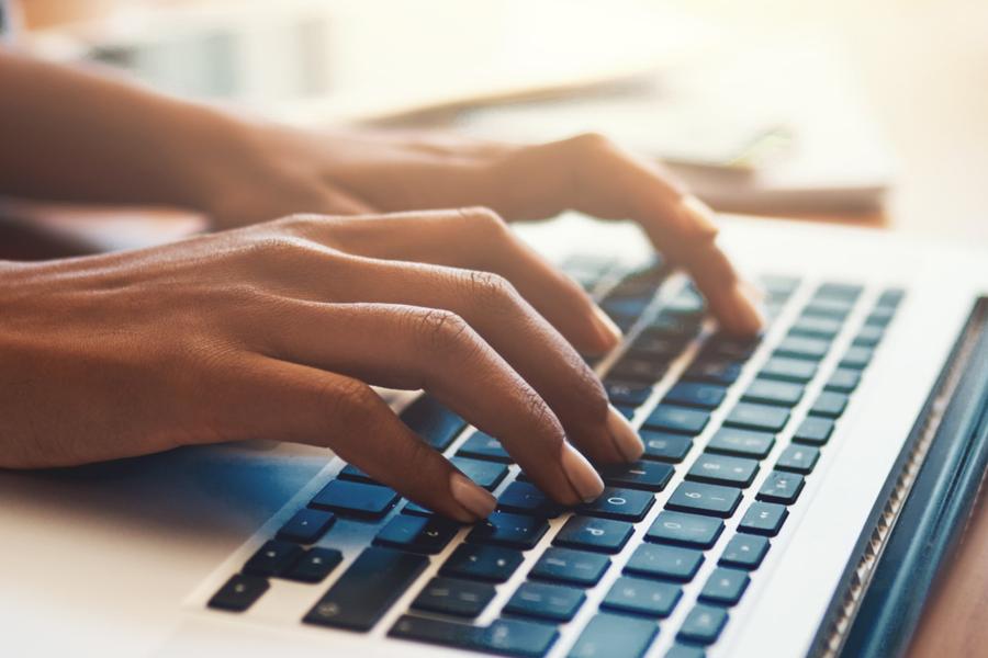 Image of a person typing on a laptop keyboard