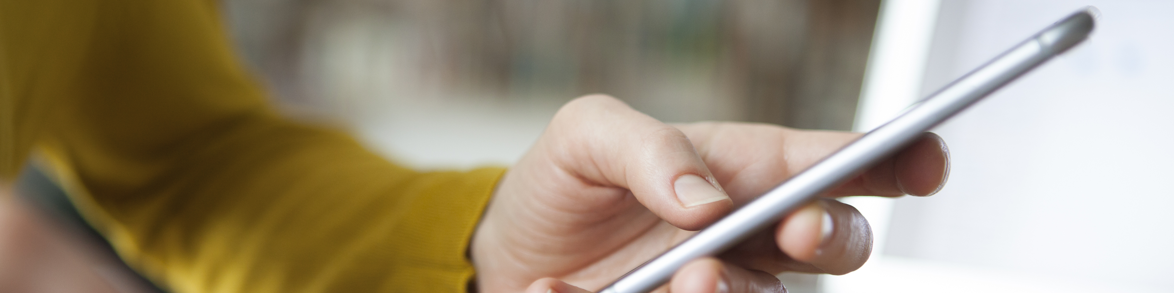 Lifestyle image of man with wedding ring holding his phone wearing mustard yellow sweater, reflection, Q3 2021, TAA NA US - Preparer