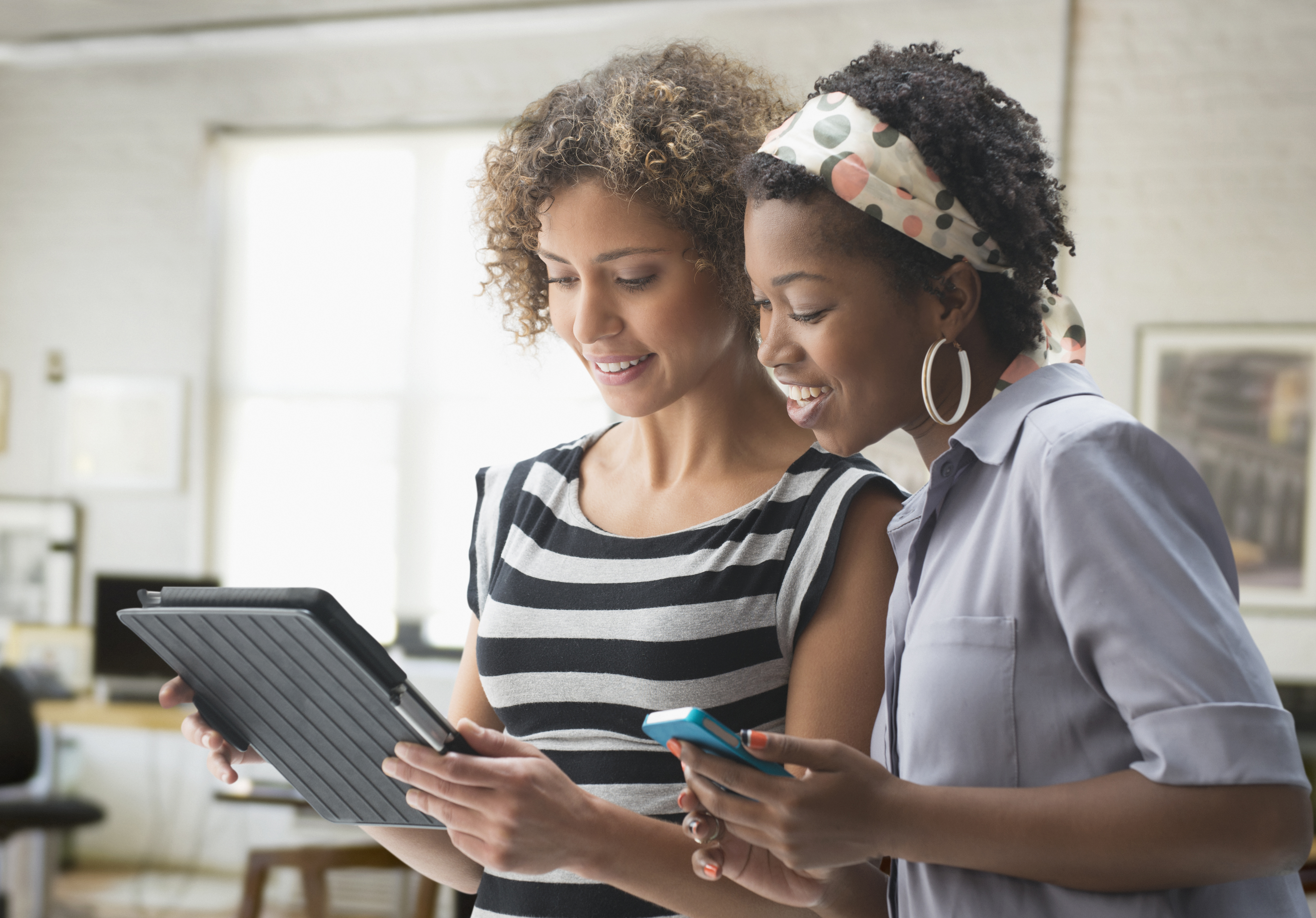 Women using digital tablet in office