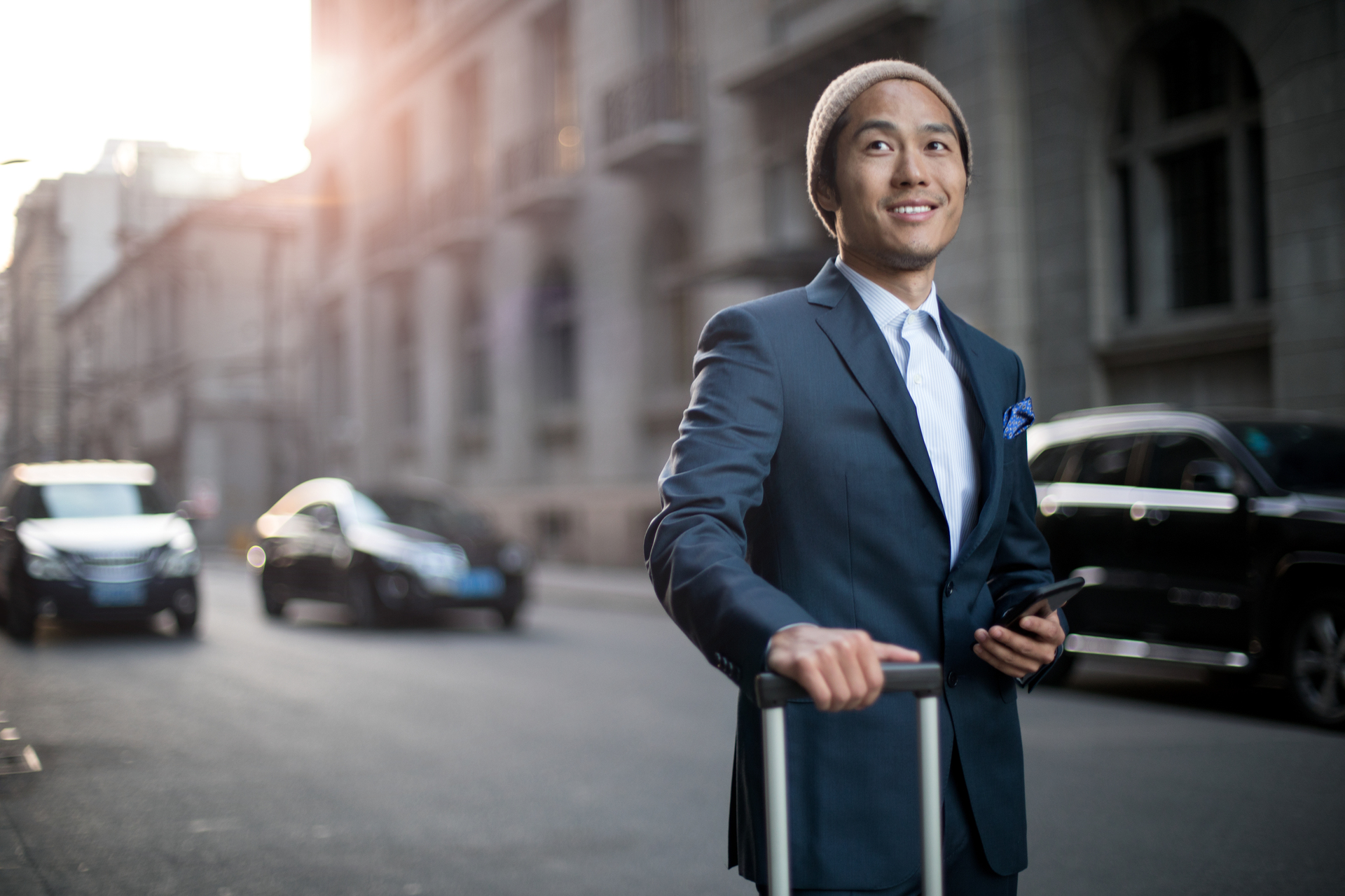 Portrait of Asan businessman with the bags at the street waiting for taxi