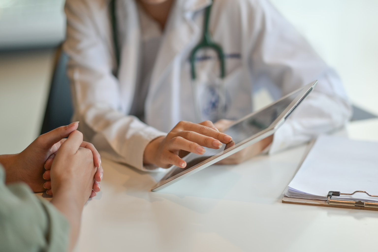 Doctor showing a patient some information on a digital tablet