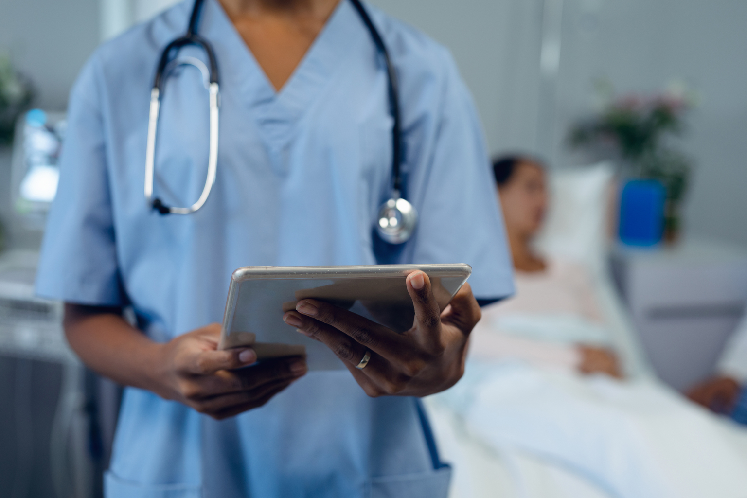 nurse holding tablet at bedside