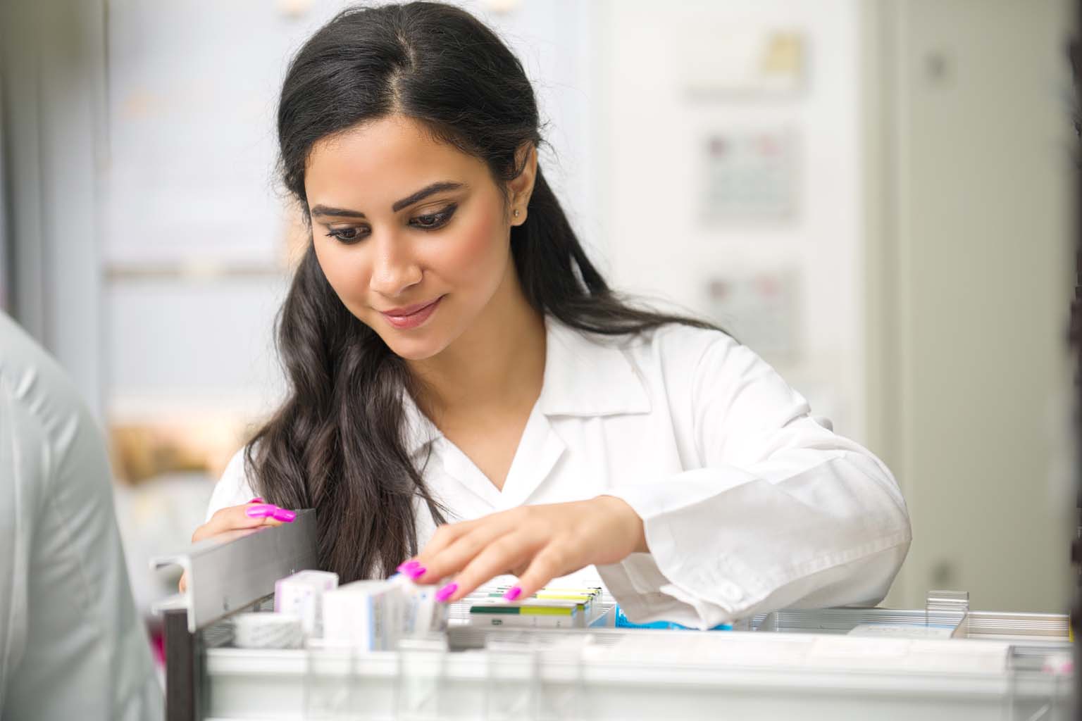 pharmacist examining medication in pharmacy