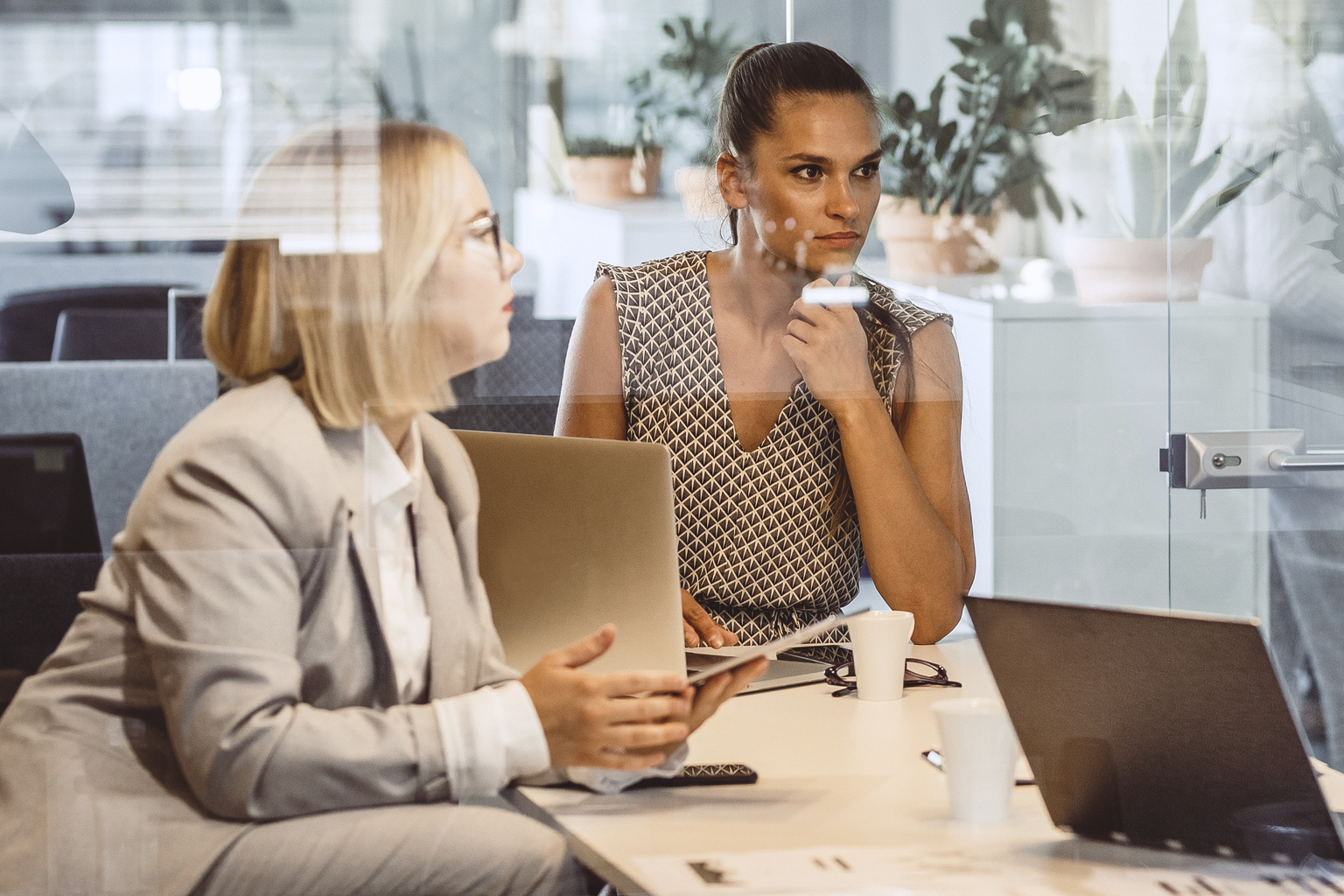 Business people discussing on a project in the see through conference room.