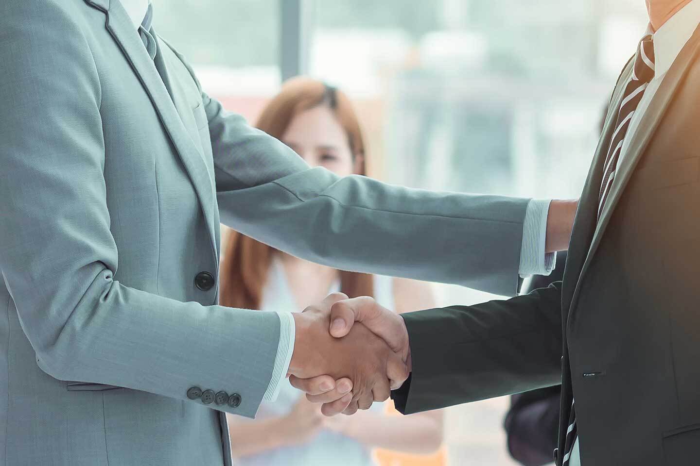 Men shaking hands and others clapping