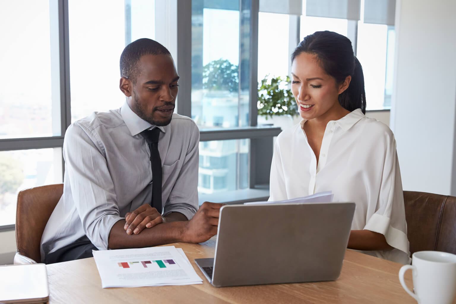 Two people sitting at a computer using CCH Axcess Engagement Essentials to flow trial balance data into their tax preparation software