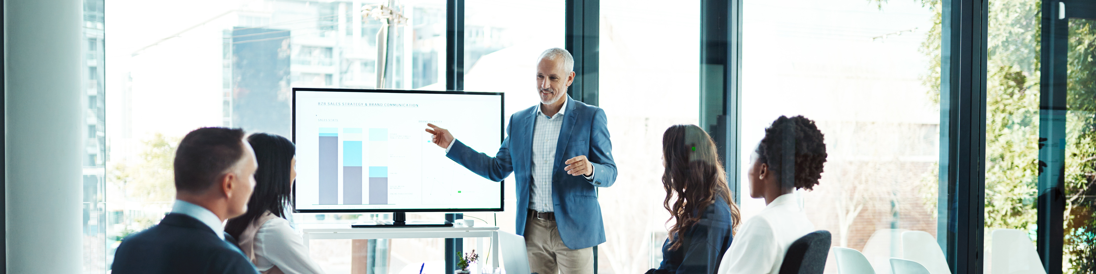 Senior executive with his team discussing data in a conference room. Working as a Team. OneWebGetty2021