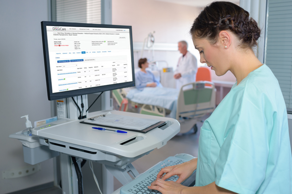 Nurse typing at computer outside of a patient hospital room, patient and doctor in background