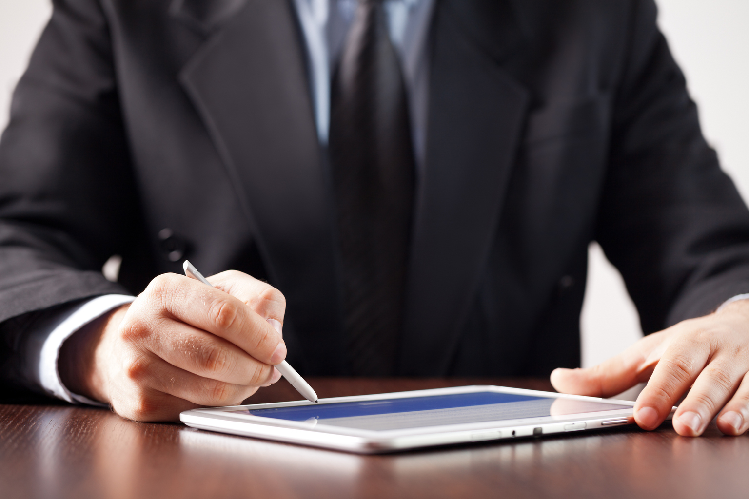 Man signing tablet with stylus