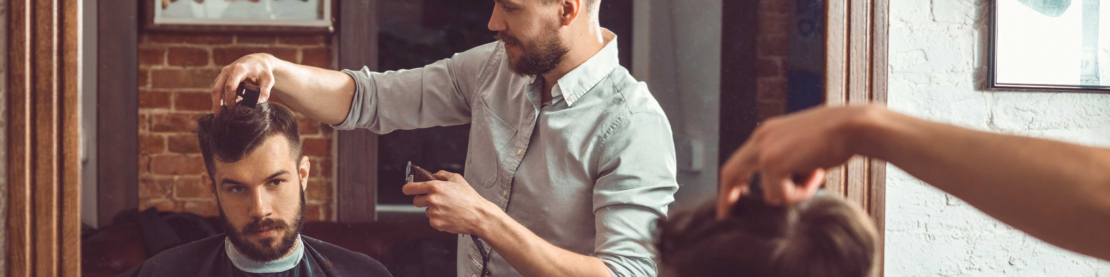 A barber giving a man a hair cut