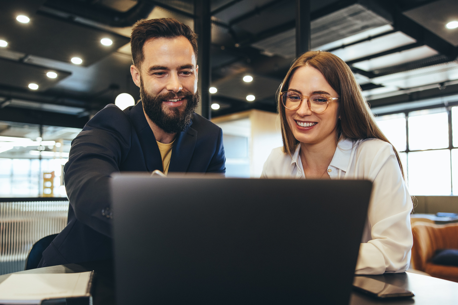 two professionals looking at a laptop screen