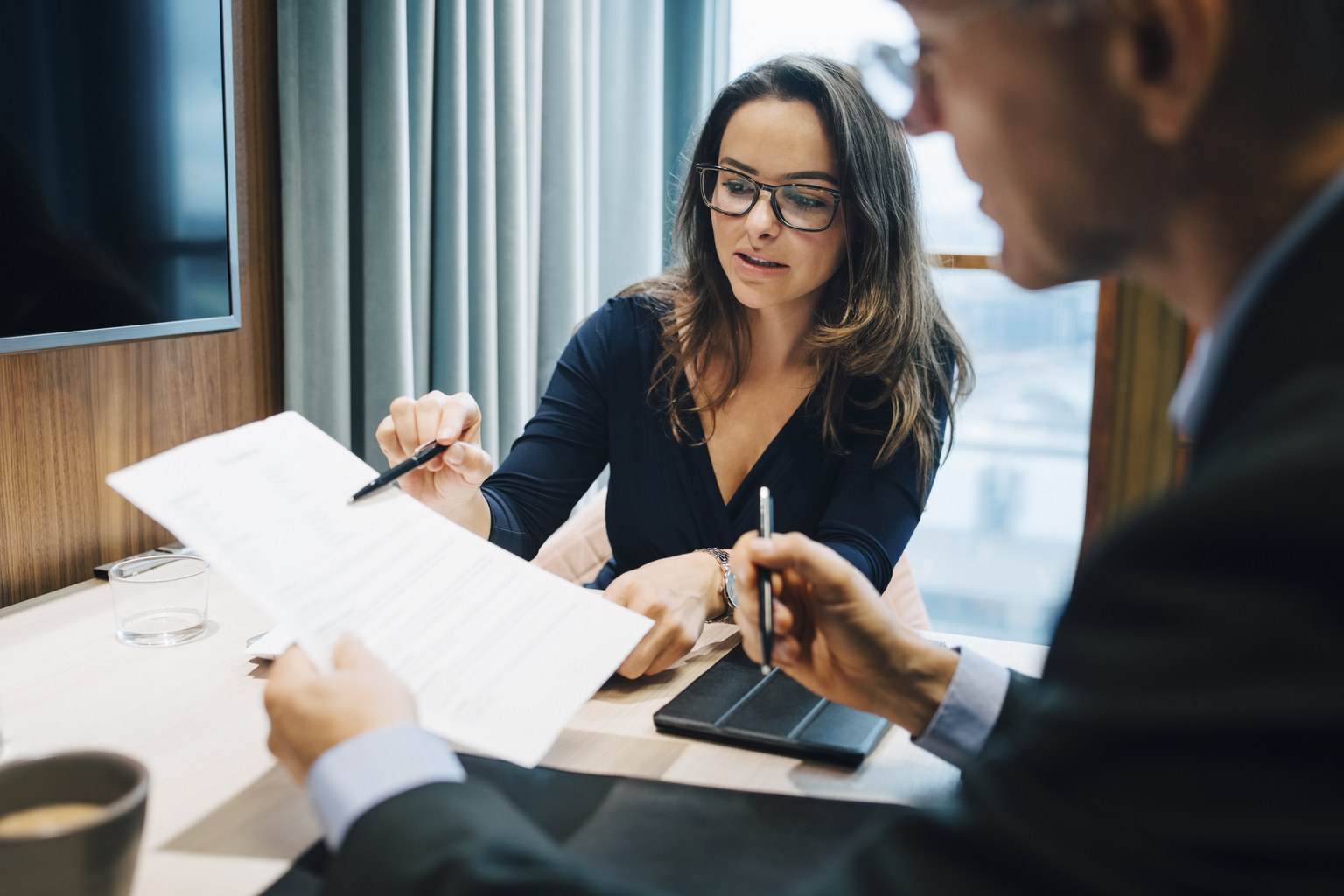 Male and female entrepreneur brainstorming over document.