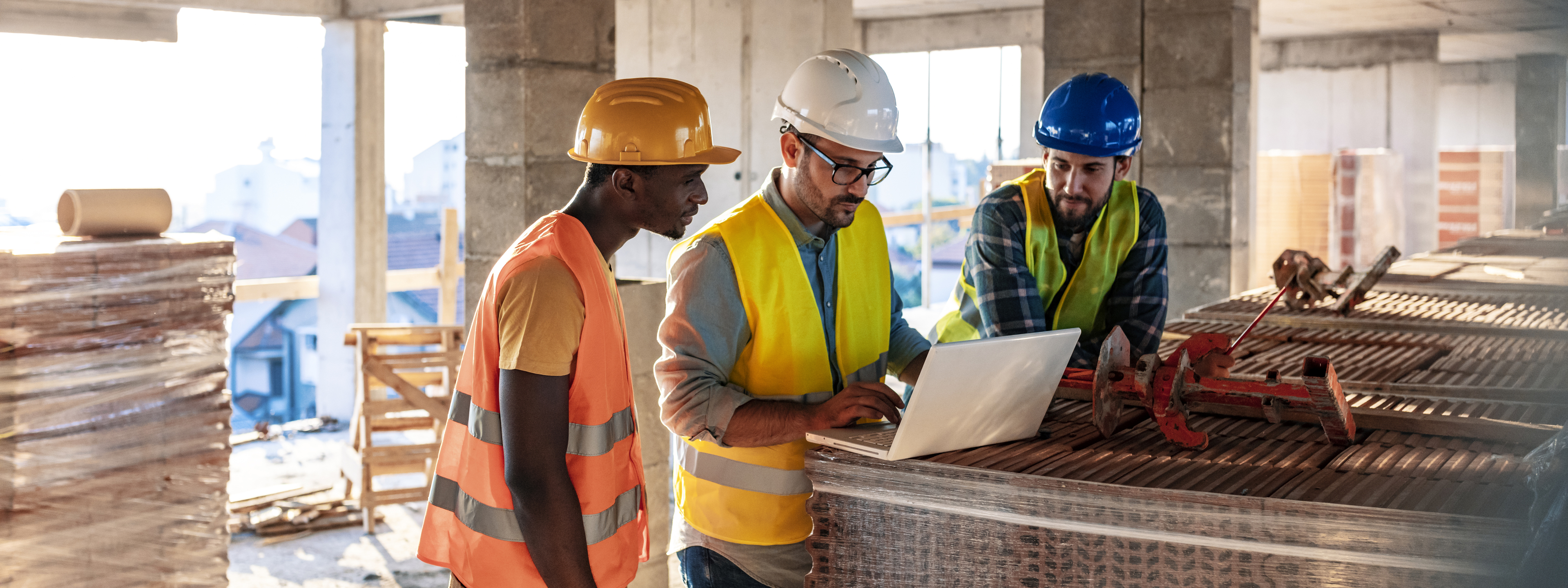 Engineer, architect and business man working on the engineering project at construction site. House building concept. Photo of young male architect engineer using laptop computer.