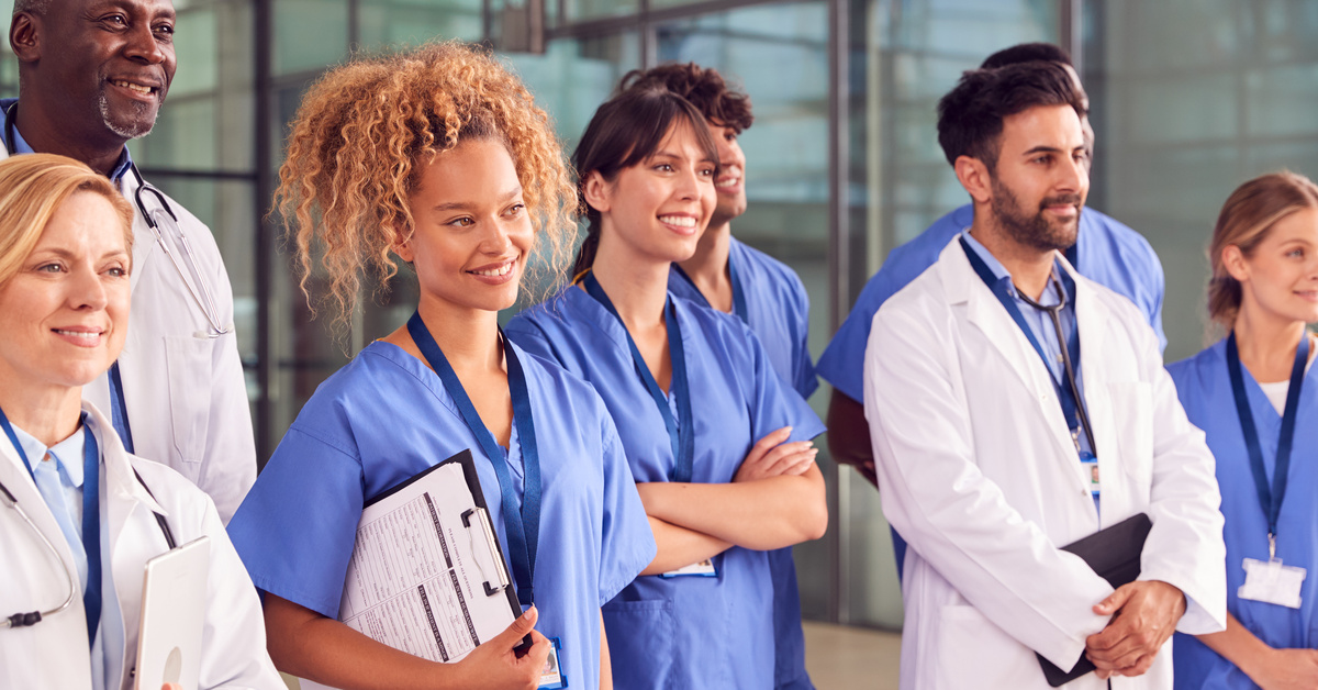 Smiling Medical Team Standing In Modern Hospital Building