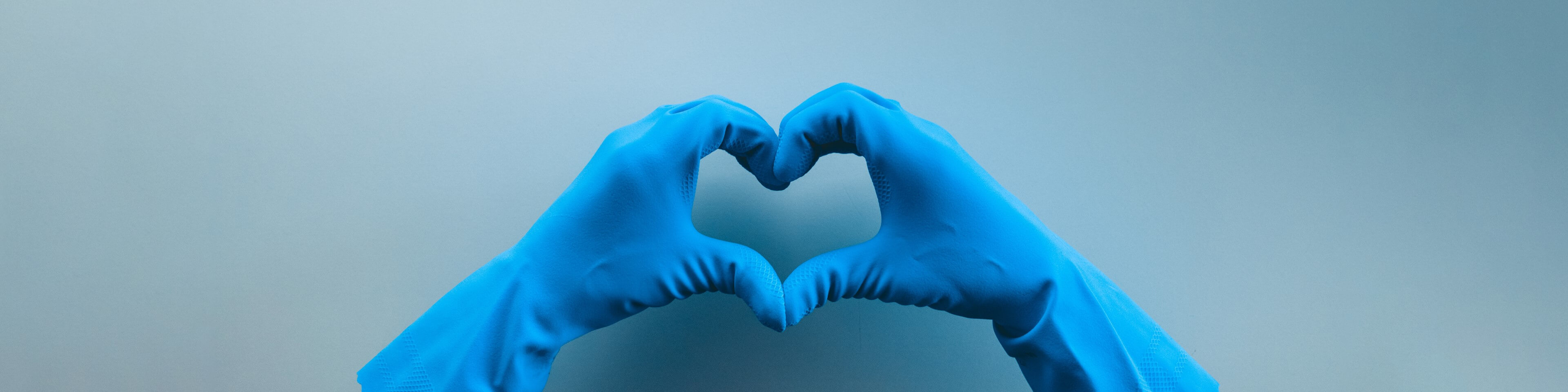Nurse wearing protective gloves forming a heart