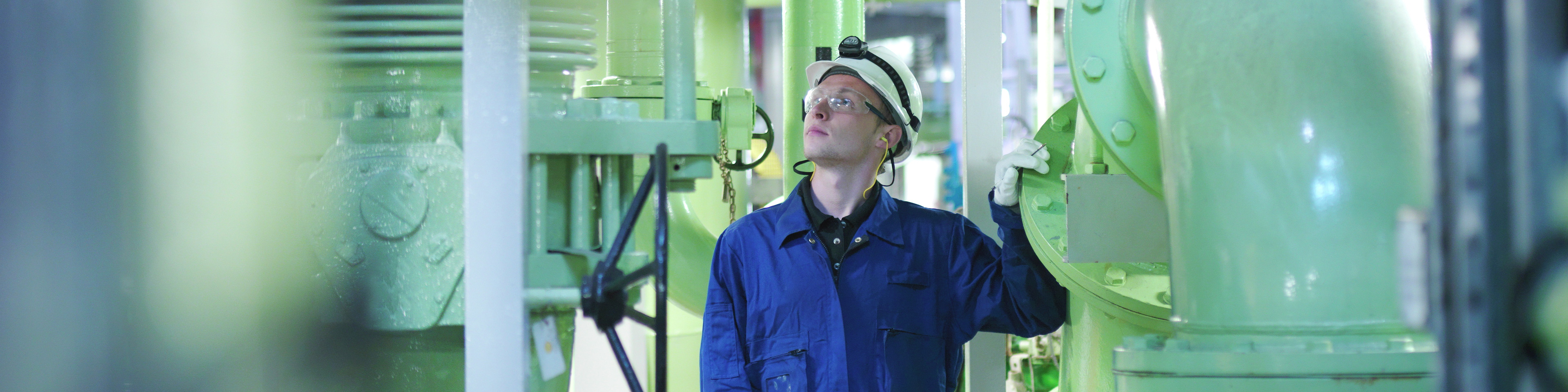 An engineer in hard-hat inspecting fuel and power generation machines