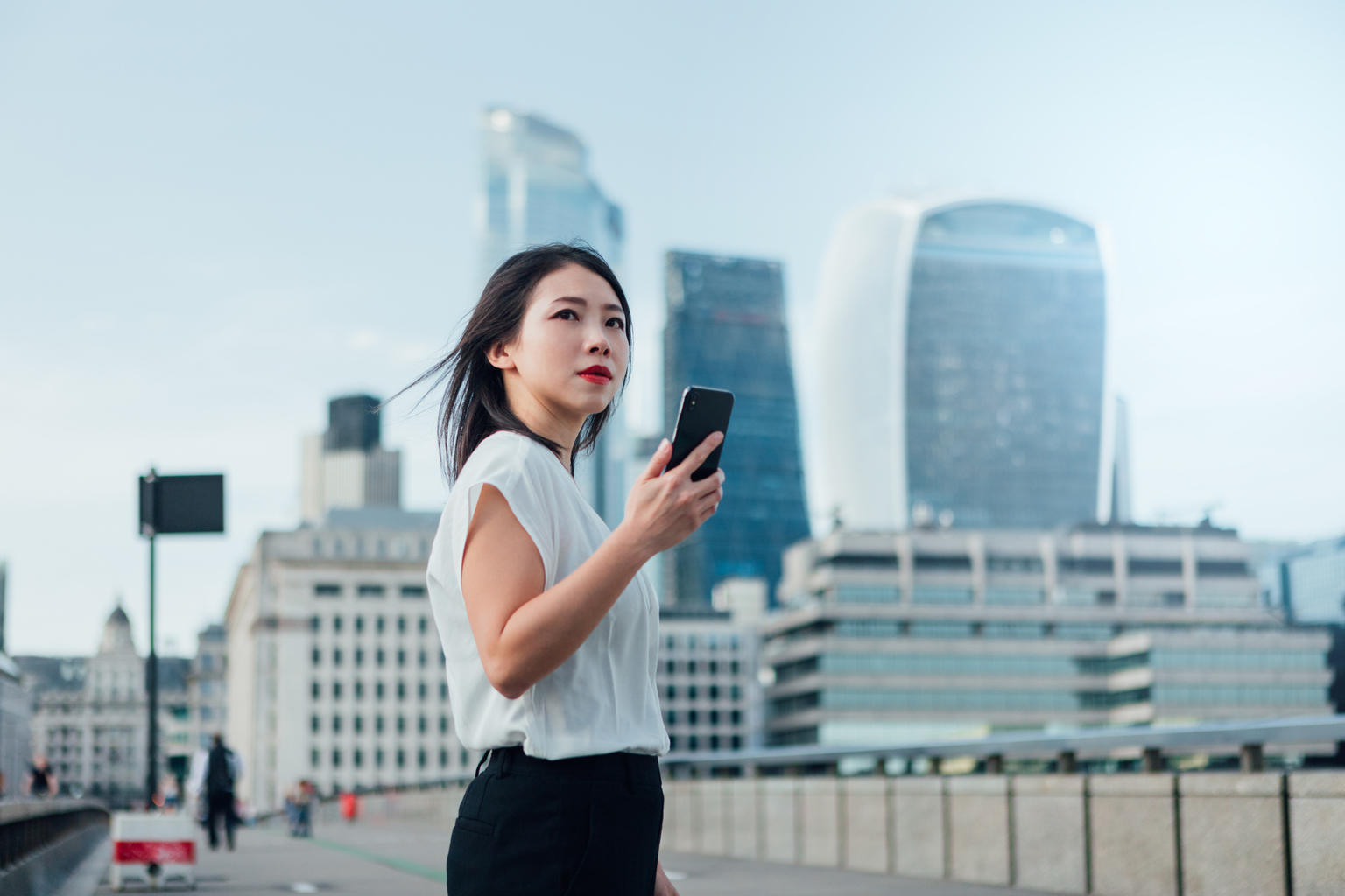 Confident Businesswoman Commuting To Work With Smart Phone In The City 