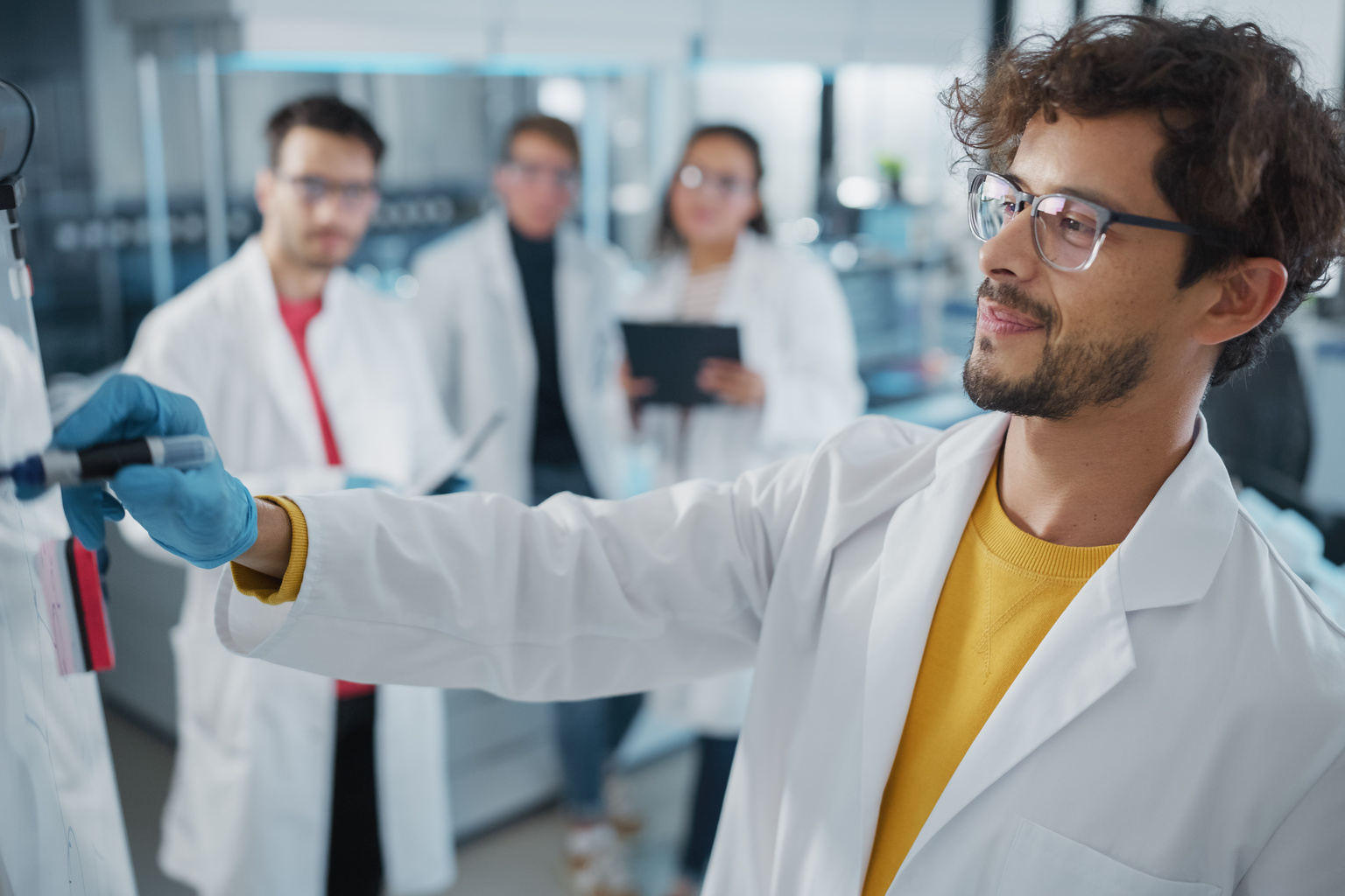 Medical professional using whiteboard to illustrate concept to colleagues