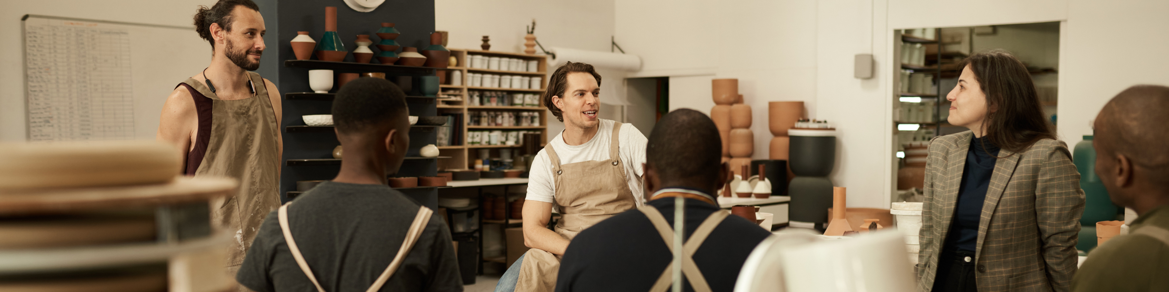 Diverse ceramics studio team talking during a meeting together