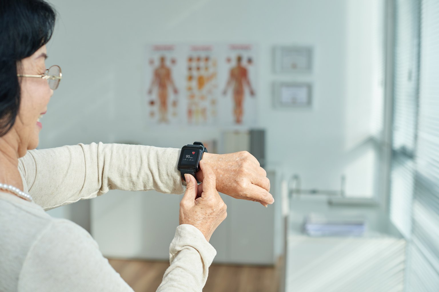 older woman looking at smart watch on her wrist