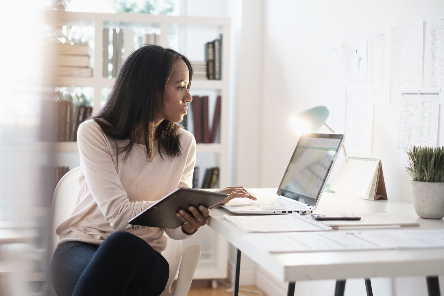 Mixed race businesswoman using laptop