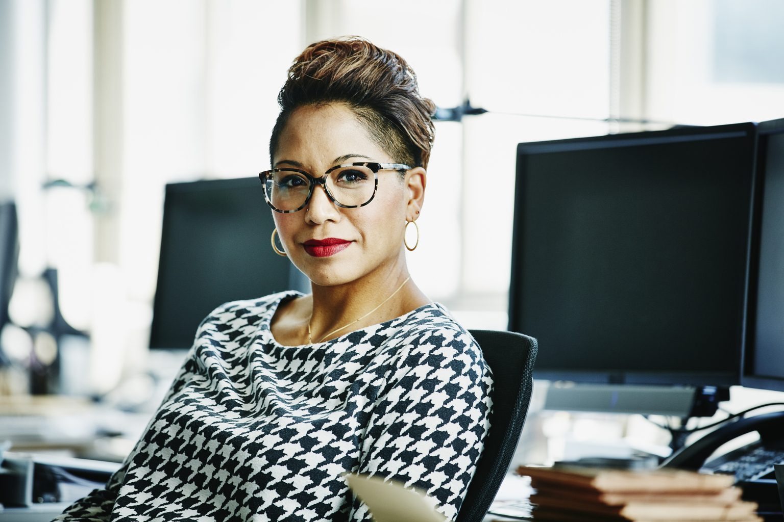 Smiling businesswoman seated at office workstation