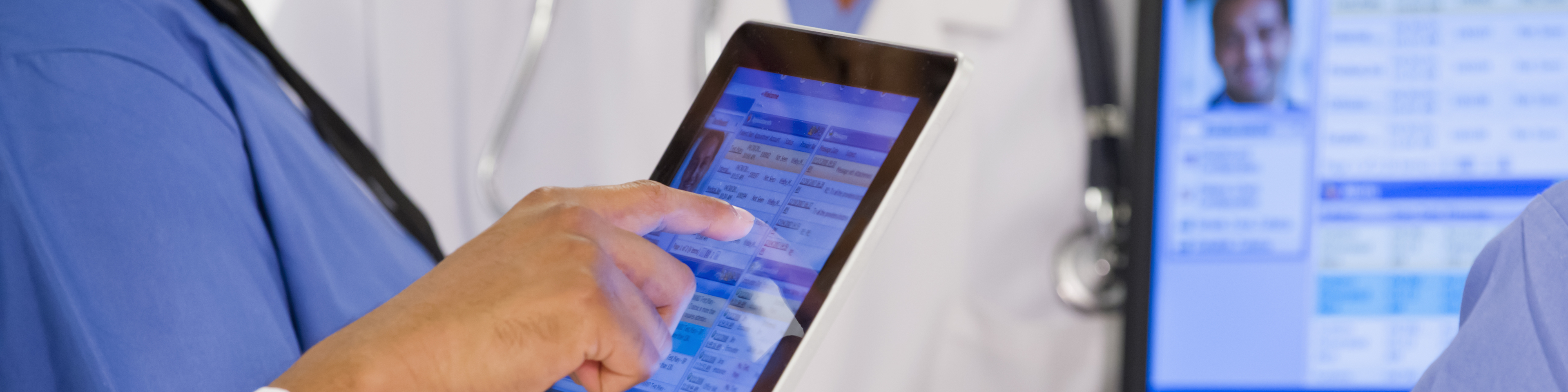 Doctors using digital tablet together in hospital