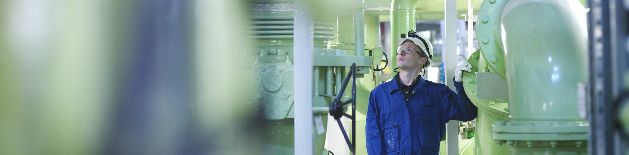 An engineer in hard-hat inspecting fuel and power generation machines