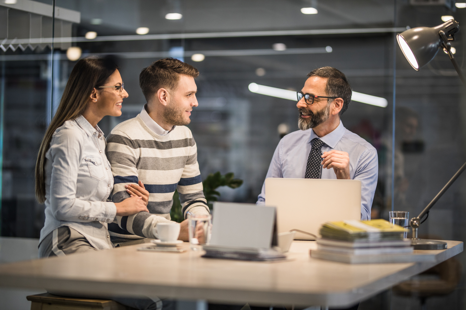 Smiling couple communicating with insurance agent on a meeting in the office