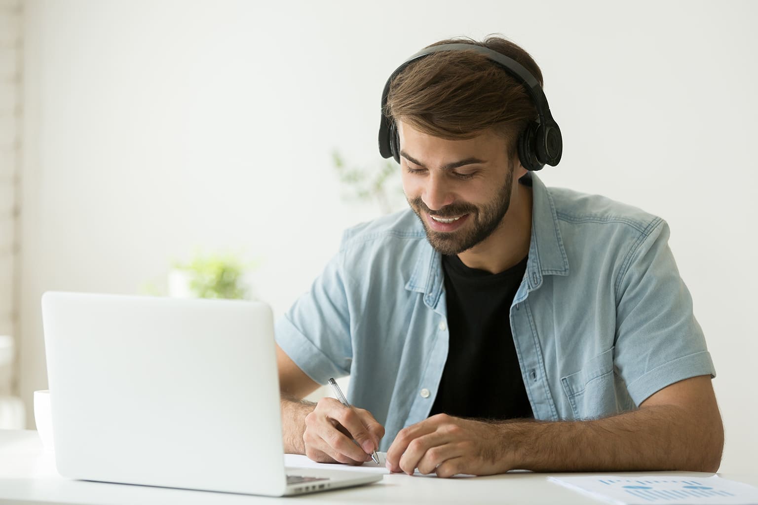 Man met hoofdtelefoon achter laptop