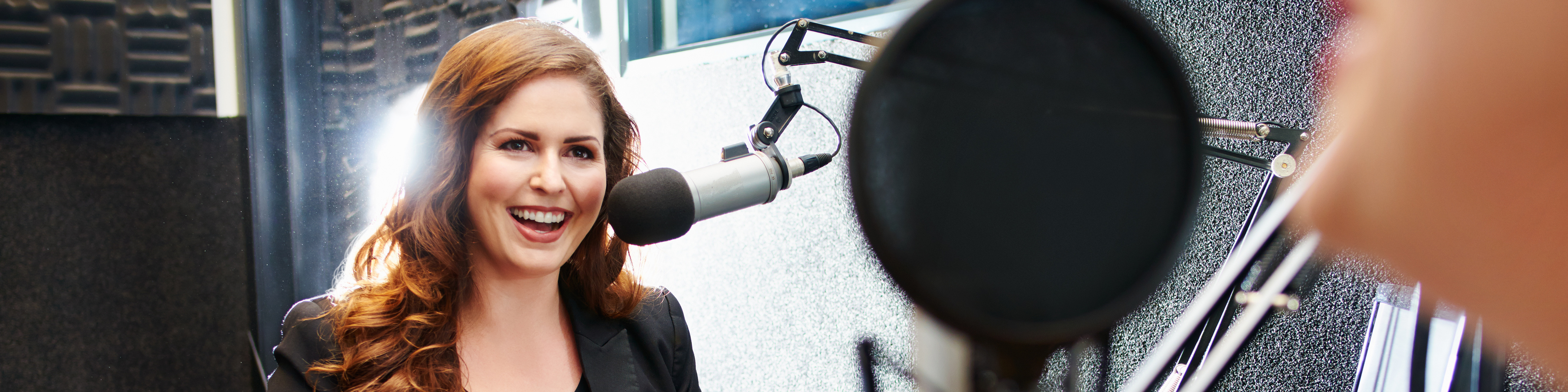 Two people sitting in the studio and talking together on a podcast