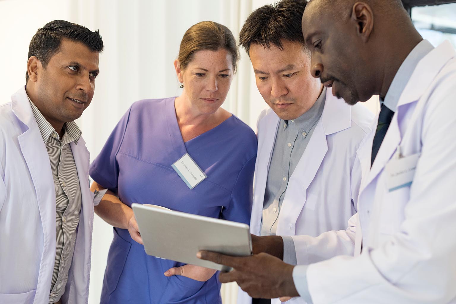 group of doctors looking at tablet