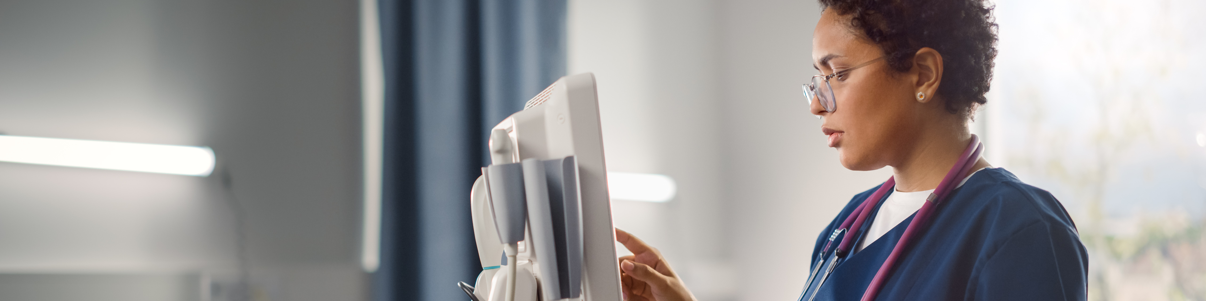 Hospital Ward: Black Female Head Nurse, Doctor, Surgeon Uses Health Care Vitals Monitoring Computer Machine. Modern High Tech Clinic with Advanced Equipment and Professional Staff