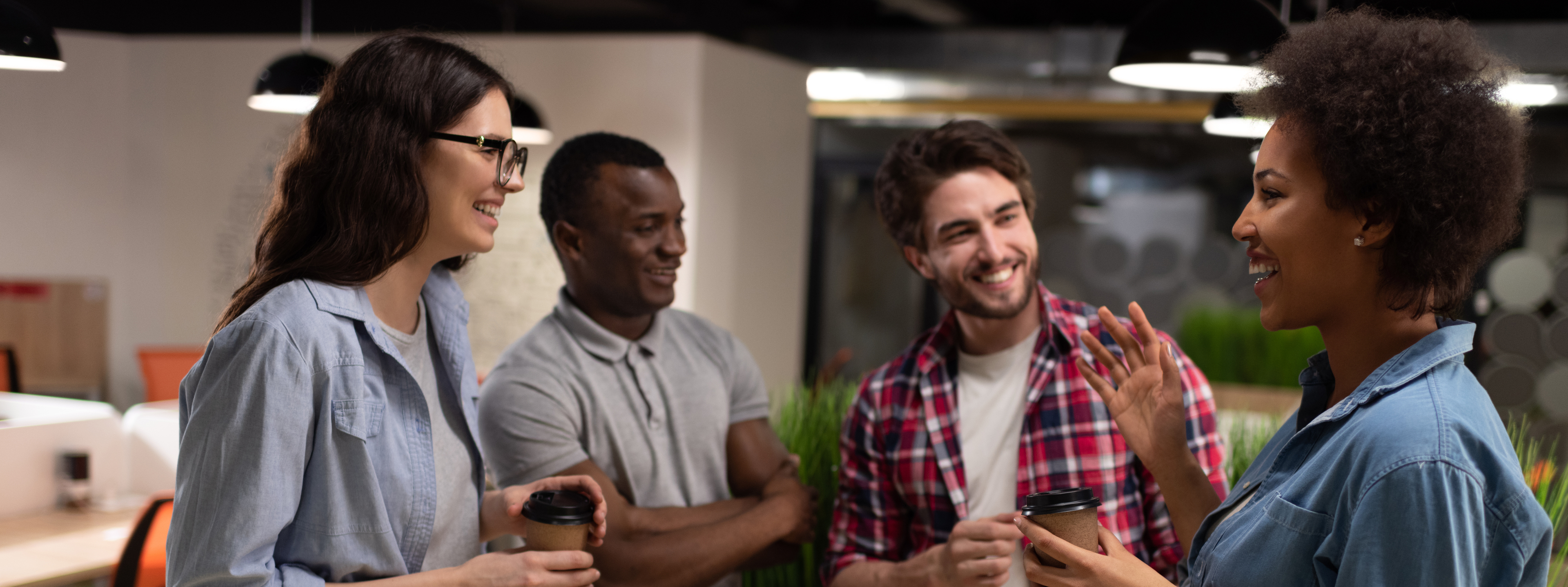 Colleagues engaging in casual conversation over a cup of coffee.