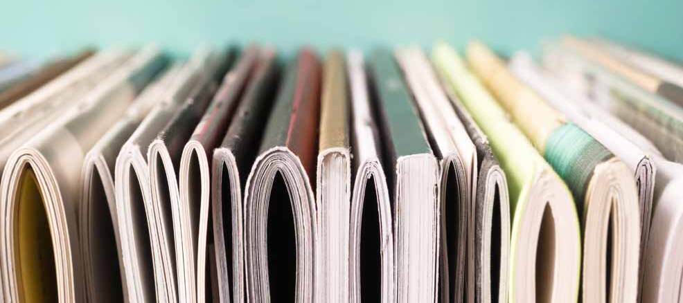 Stack of journals on their side, view of spines from the bottom