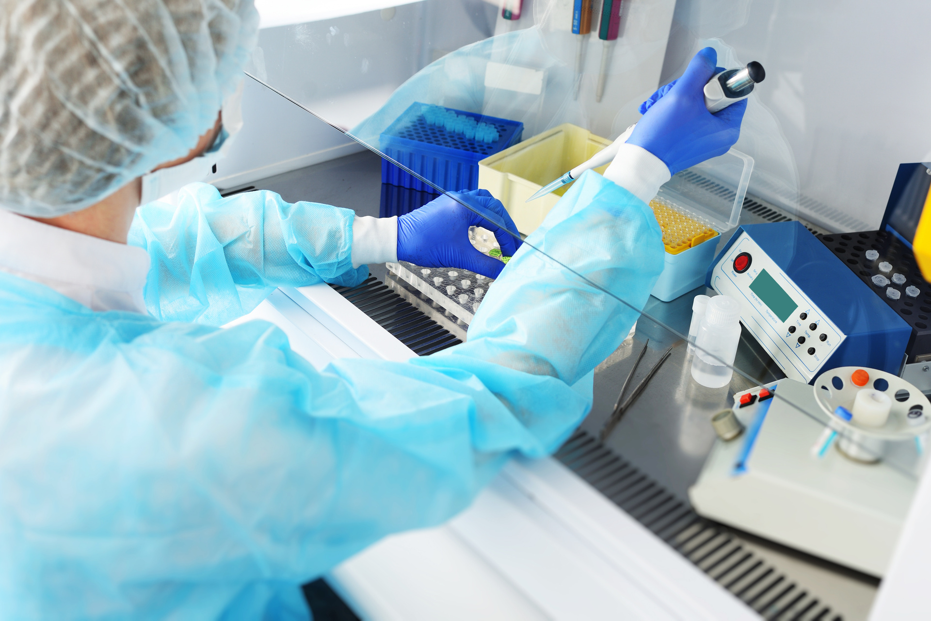 Lab technician working to pipe samples into test tubes