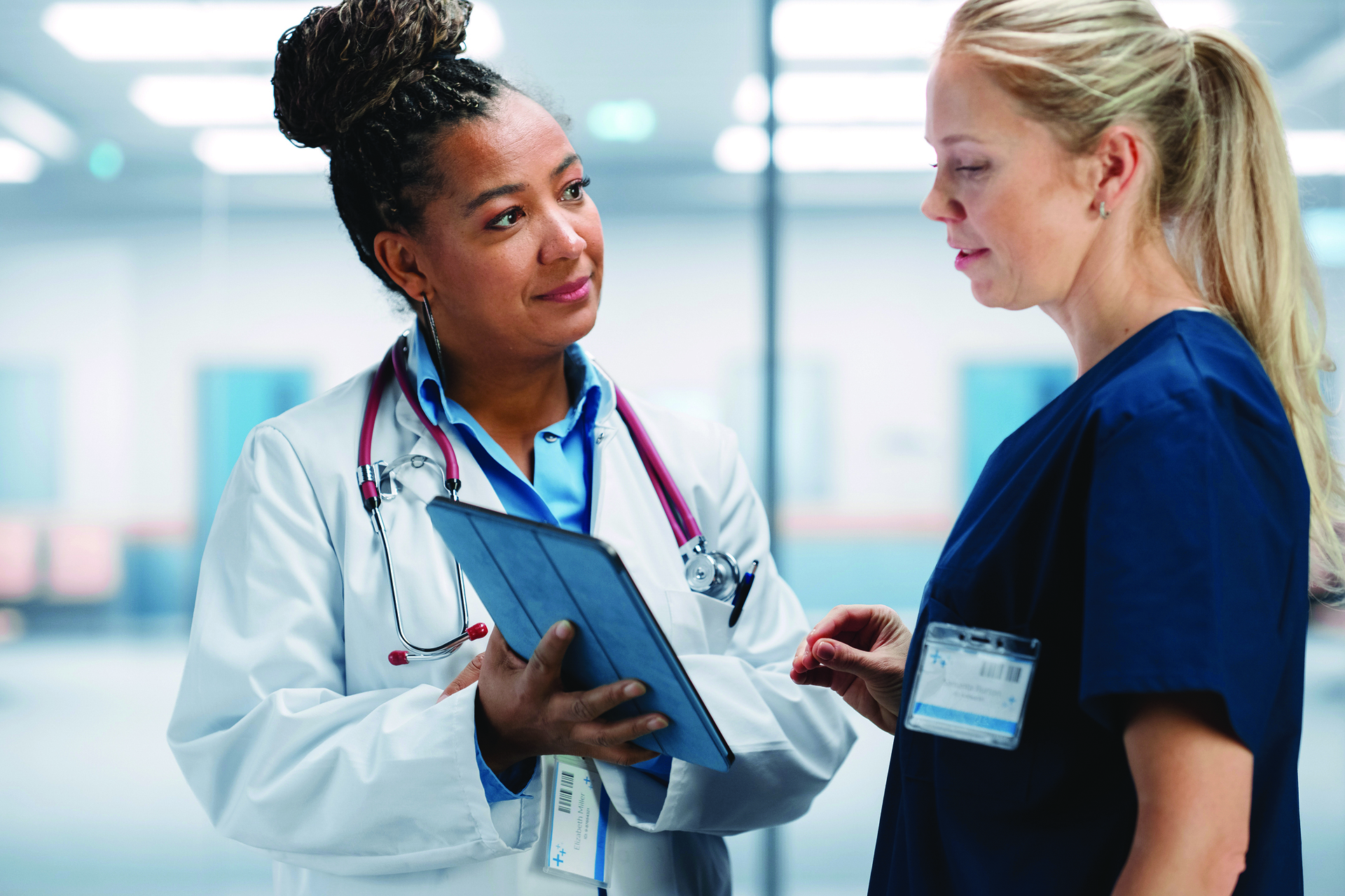 Two medical professionals reviewing data on tablet