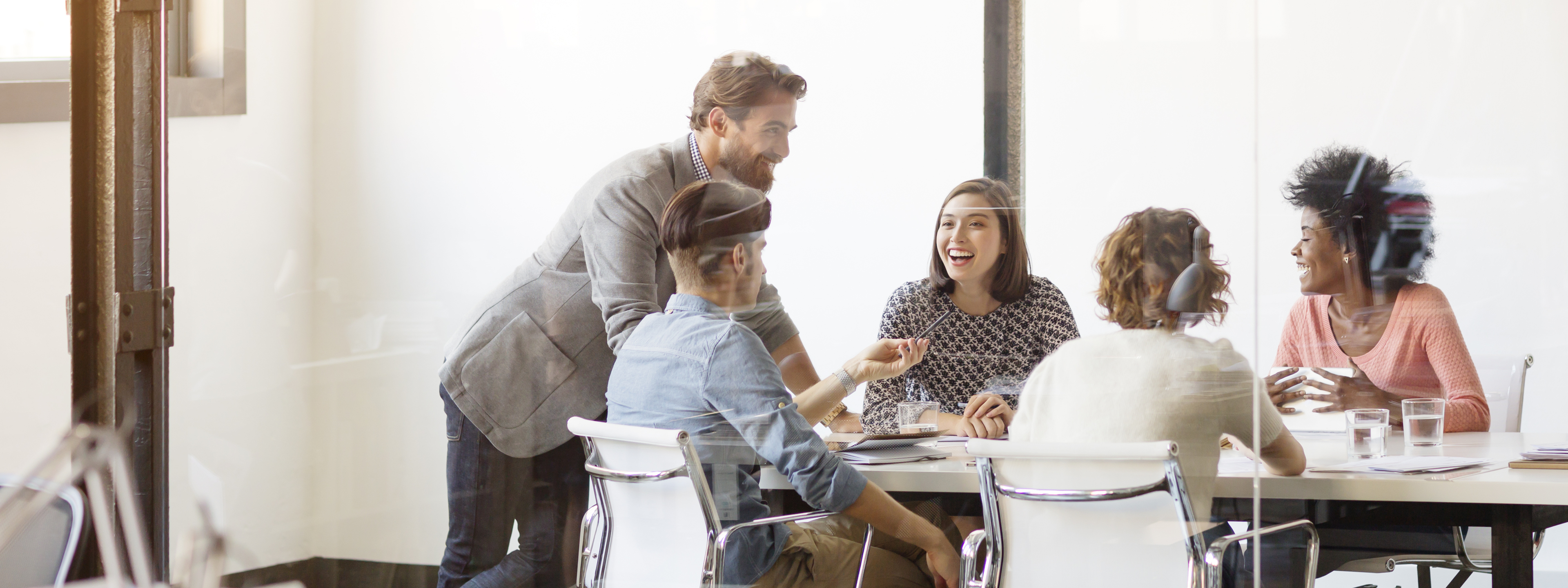 Happy young business colleagues in board room at office