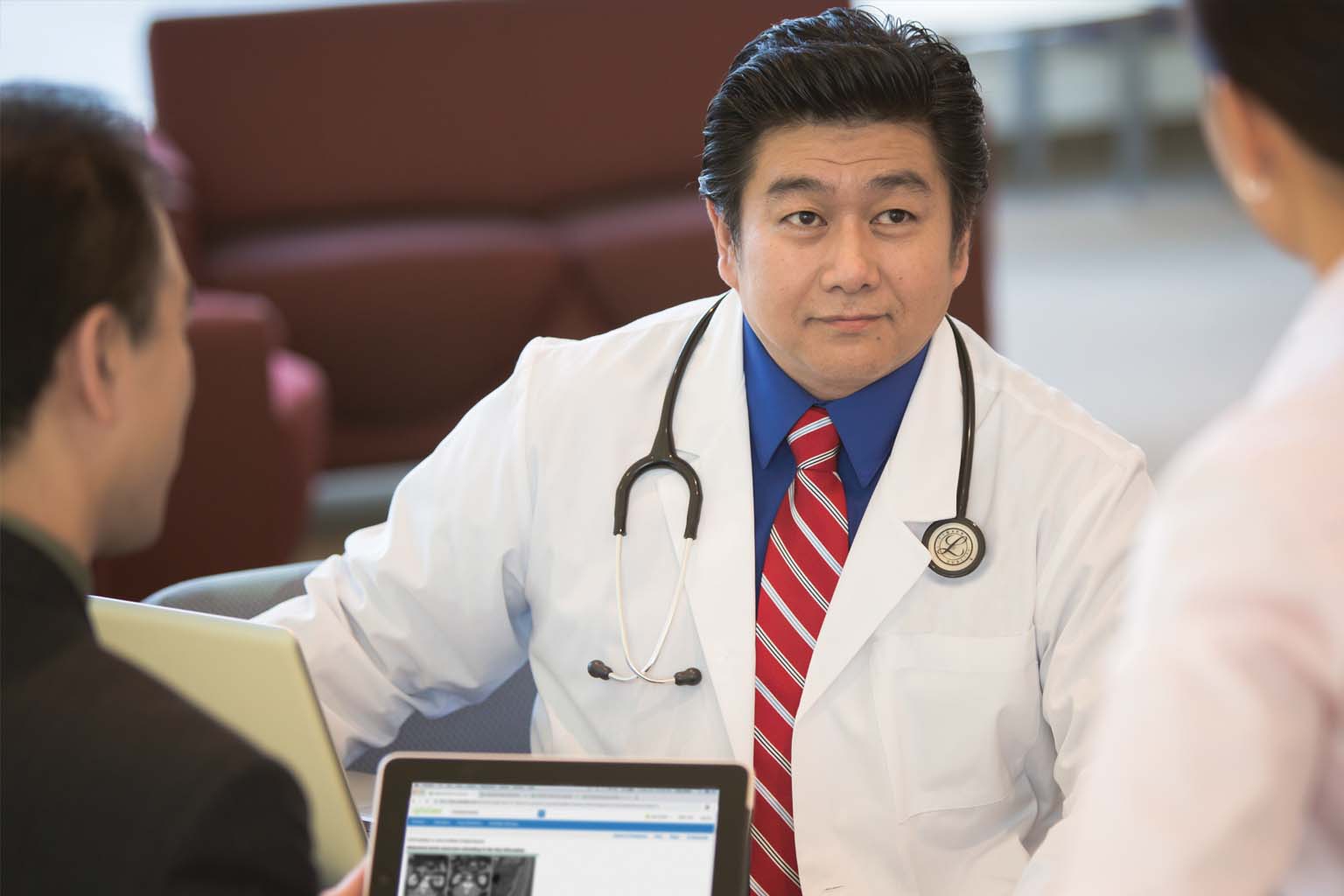 doctors discussing information displayed on a tablet