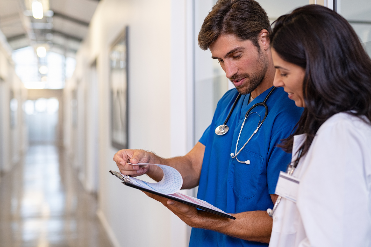 Doctor and nurse discussing medical report at clinic