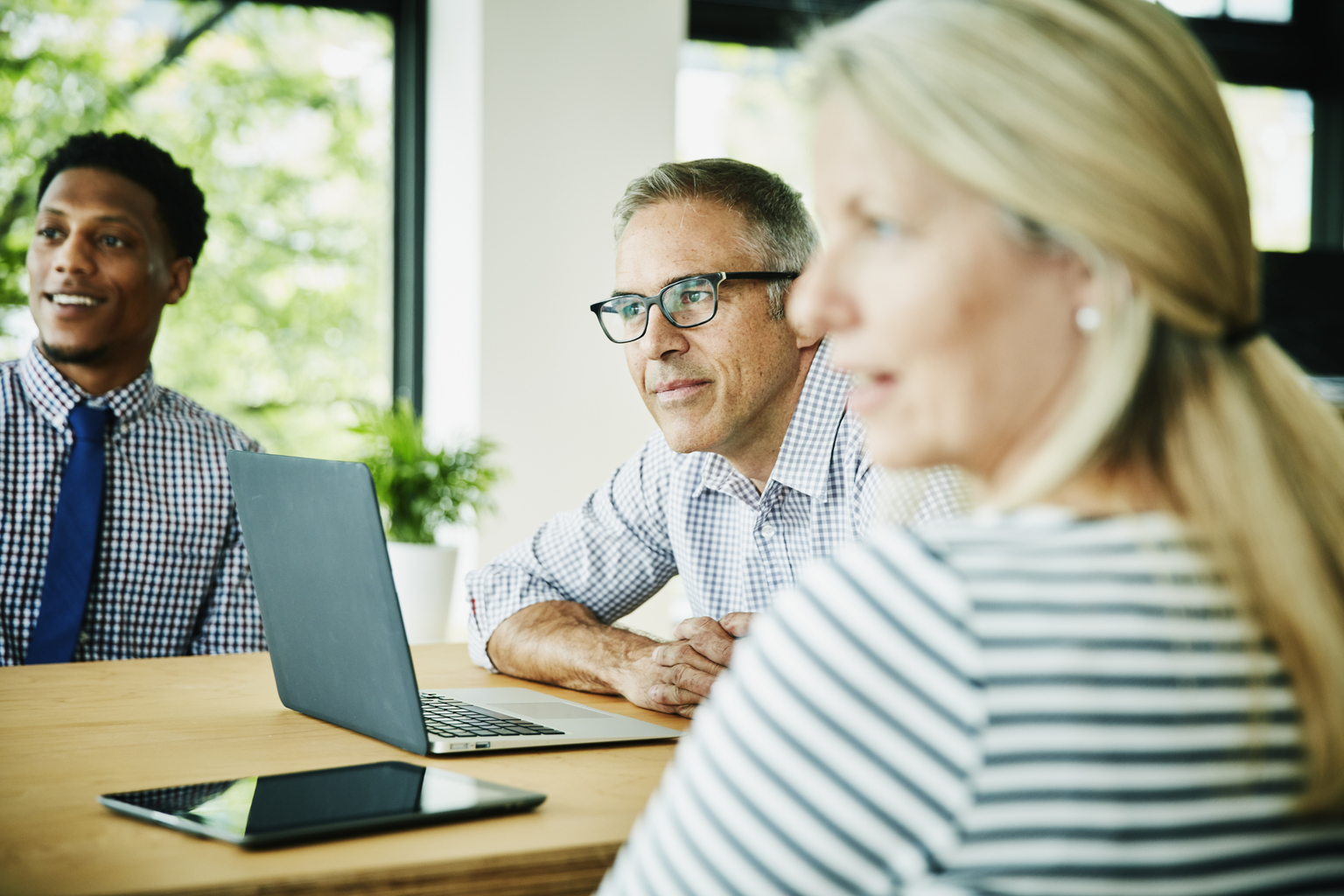 Colleagues listening during client presentation in office conference room