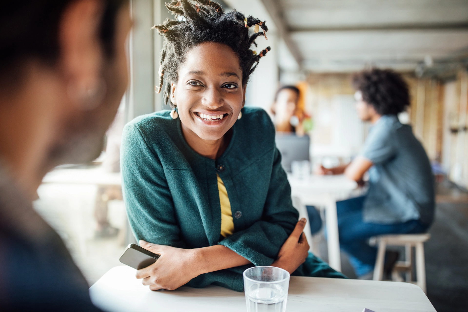 Smiling businesswoman sitting with colleague in cafeteria 