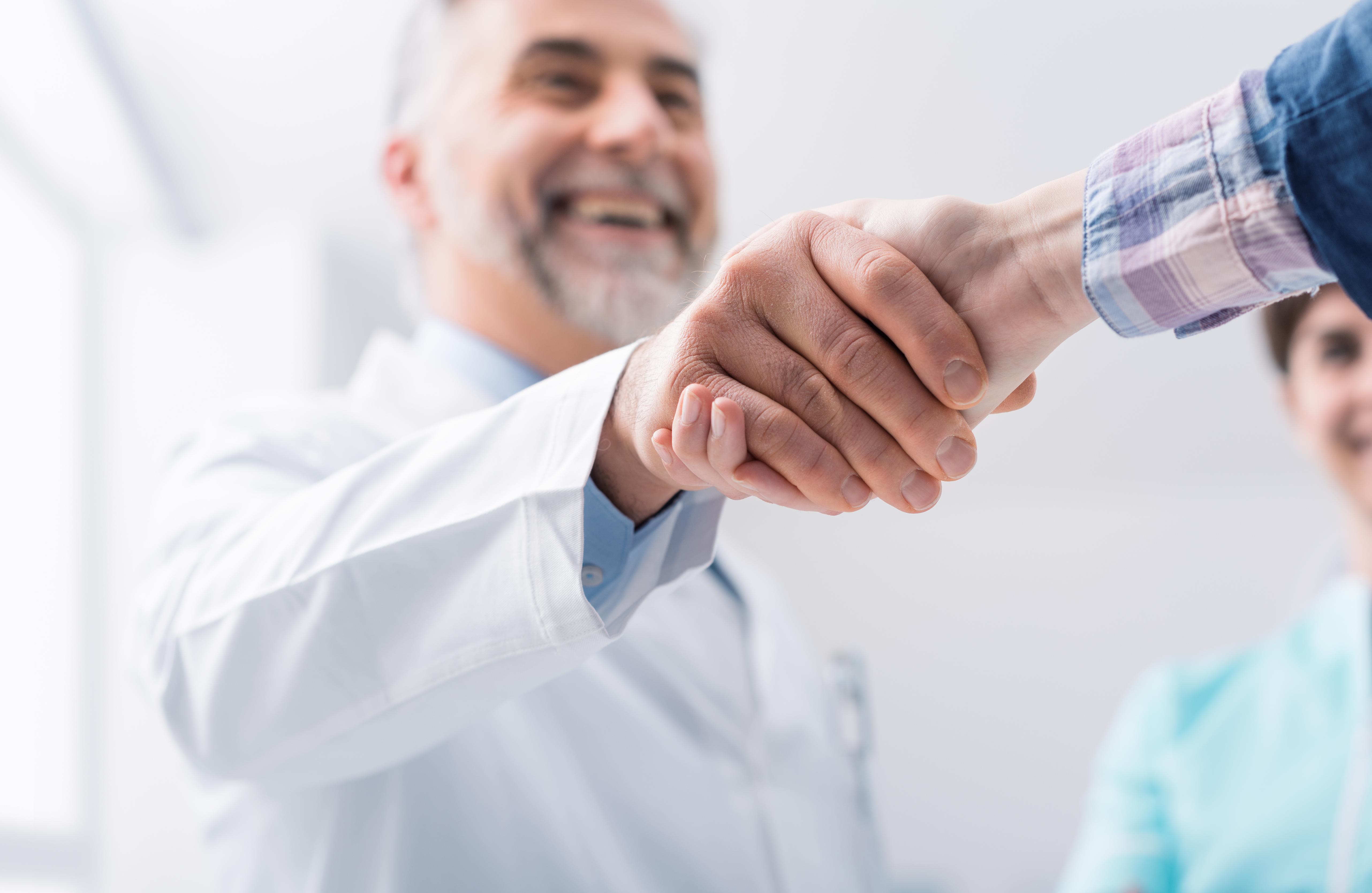 Medical professional shaking hands with patient. 