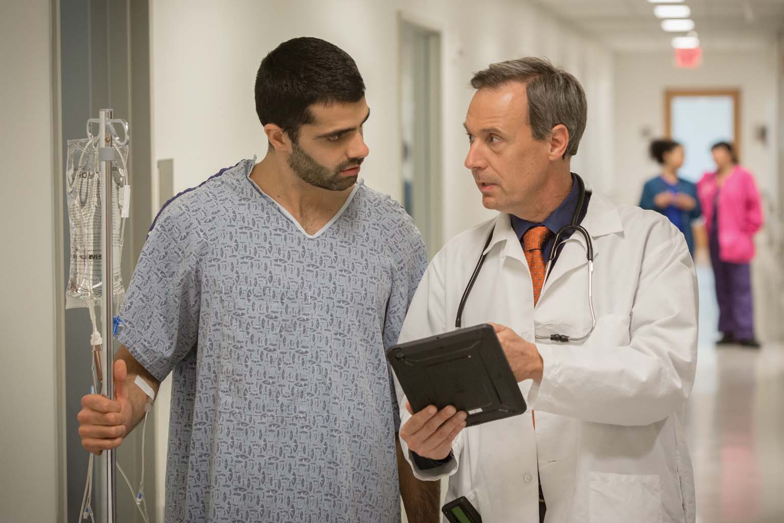doctor and patient walking and looking at tablet
