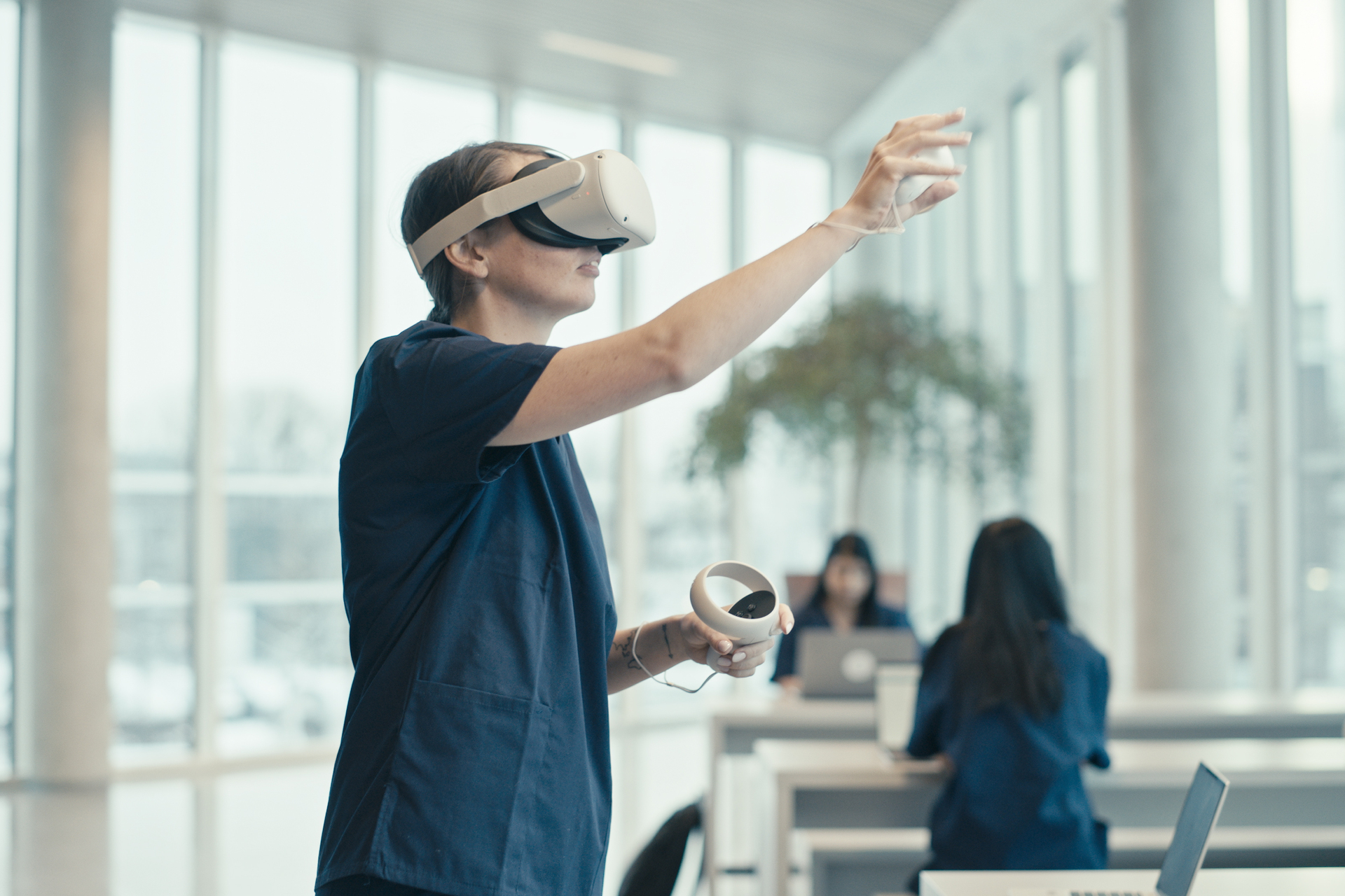 Student using vrClinicals for Nursing, using controller to reach for something in simulation