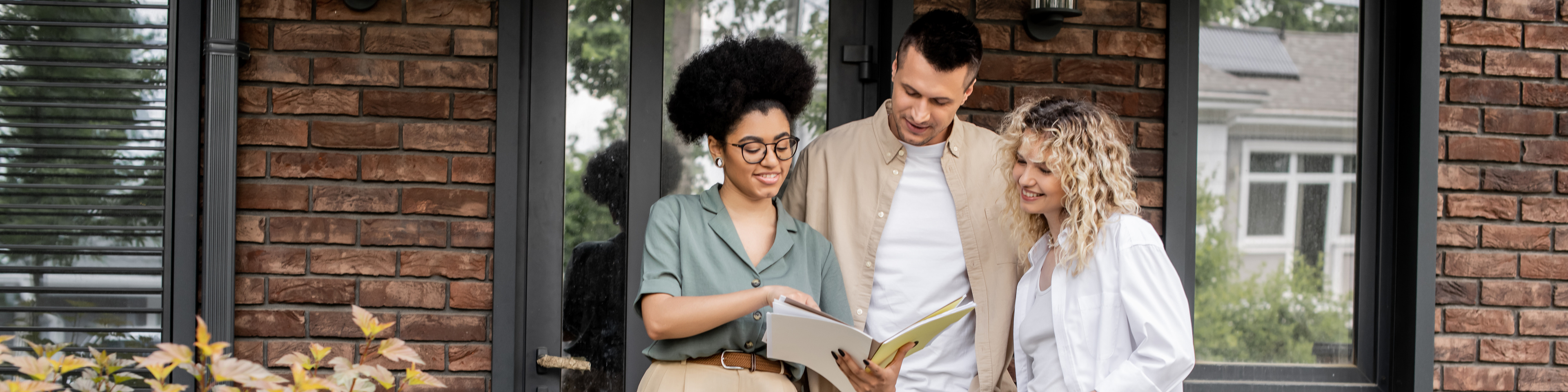 Real estate agent showing documents to smiling owners of new house