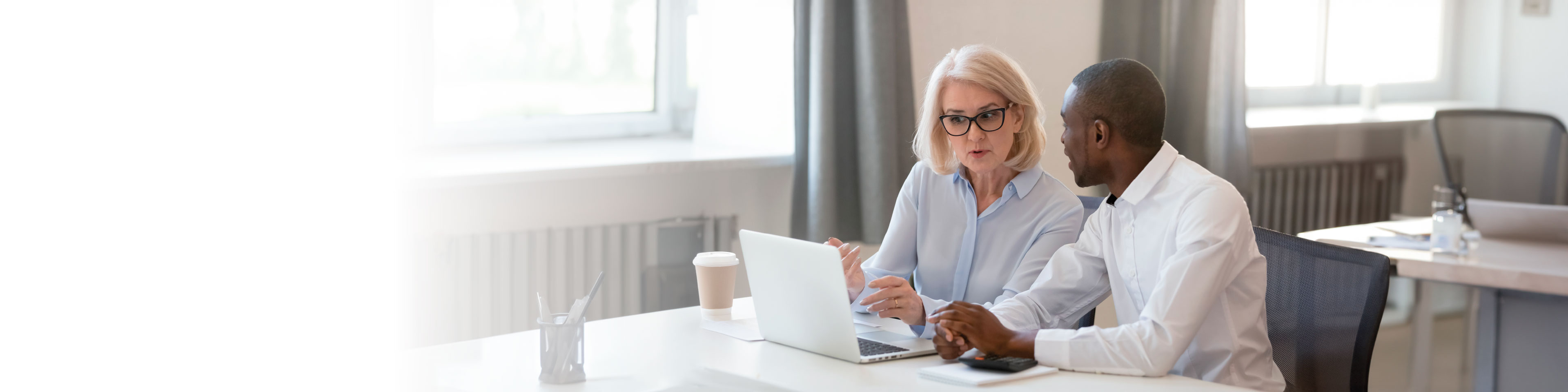 a woman and a man looking at a laptop screen