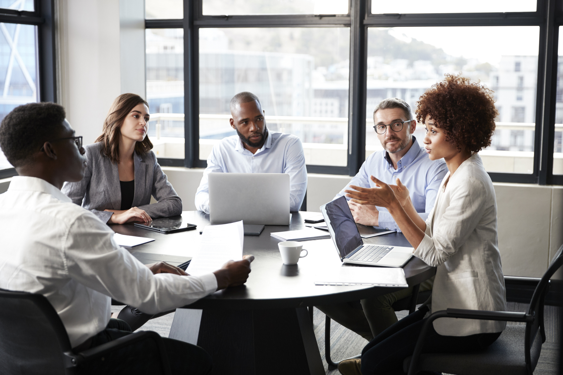 African businesswoman addressing colleagues at a corporate business meeting.