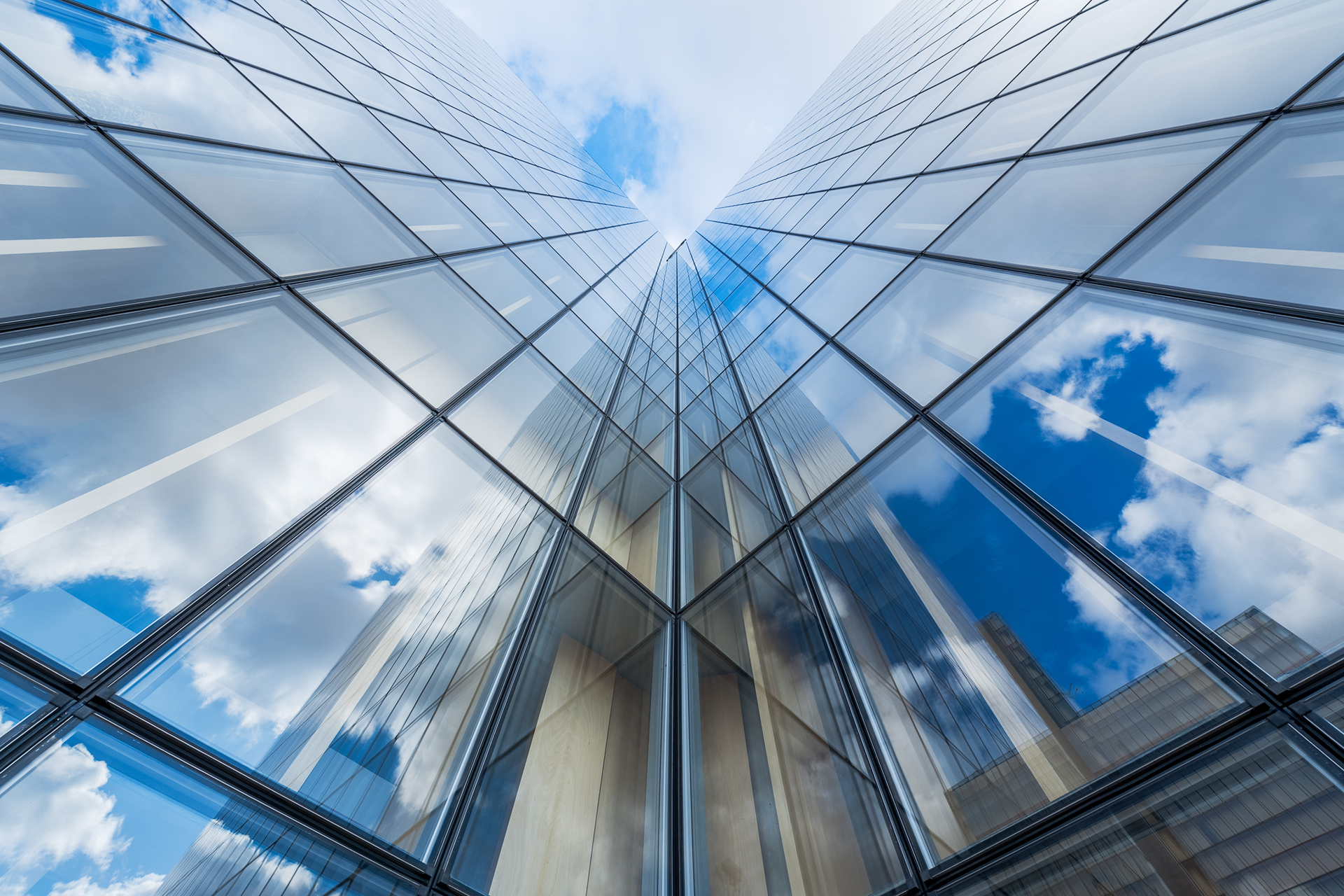 Blue sky and clouds reflections on a glass building,